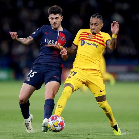 Lucas Beraldo (PSG) e Raphinha (Barcelona) em ação na Liga dos Campeões