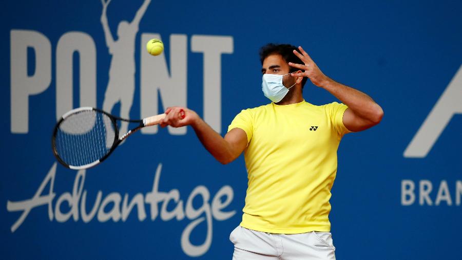 2.mai.2020 - O tenista alemão Benjamin Hassan usa uma máscara facial enquanto se aquece para uma partida de tênis - Wolfgang Rattay/REUTERS
