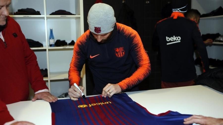 Lionel Messi assina camiseta para o jovem Anthony - Miguel Ruiz/Barcelona/Divulgação