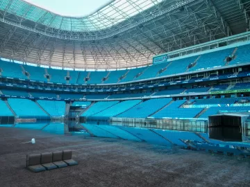 Arena do Grêmio segue alagada, mas gramado começa a aparecer; veja imagens
