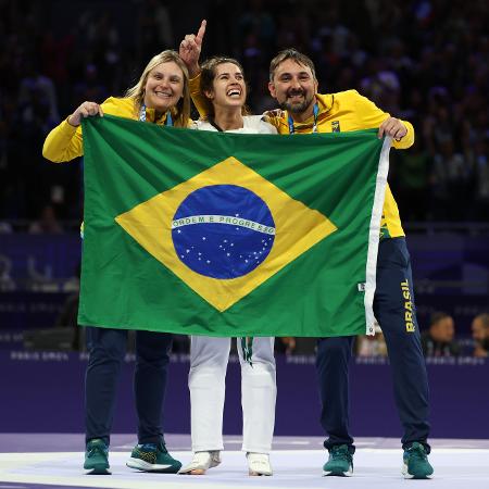 Ana Carolina Moura celebra, com os seus treinadores, a conquista do ouro na categoria até 65kg do taekwondo