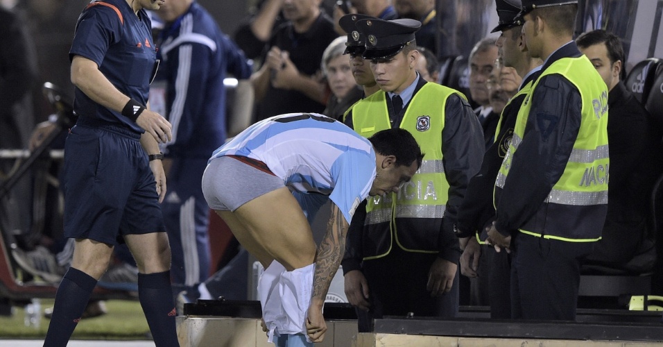 Tevez troca de calção durante jogo contra o Paraguai, na beira do gramado do estádio Defensores del Chaco, em Assunção