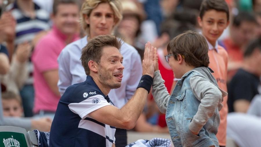 Francês Nicolas Mahut interage com o filho em quadra após partida em Roland Garros - Tim Clayton/Corbis via Getty Images