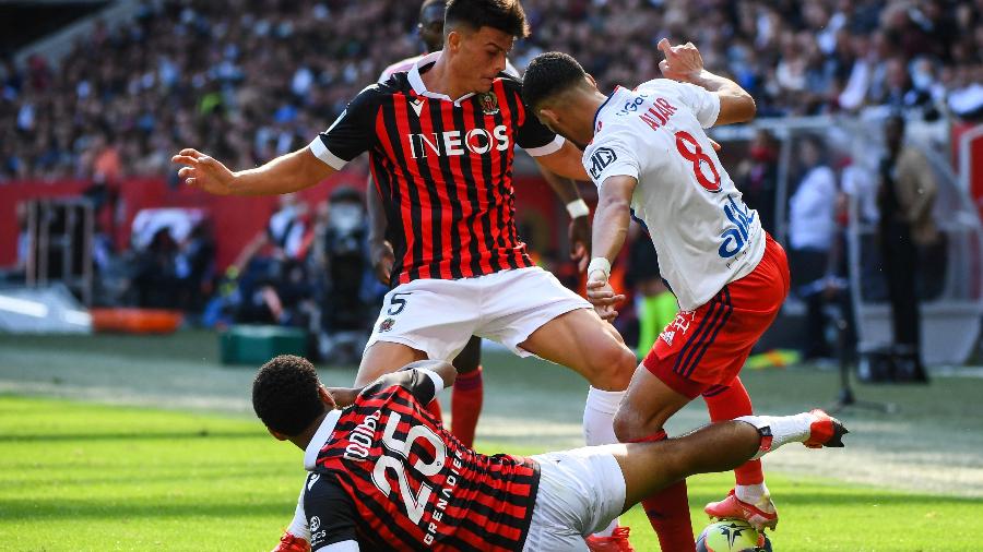Jogadores de Lyon e Nice disputam a bola em partida do Campeonato Francês - CLEMENT MAHOUDEAU / AFP