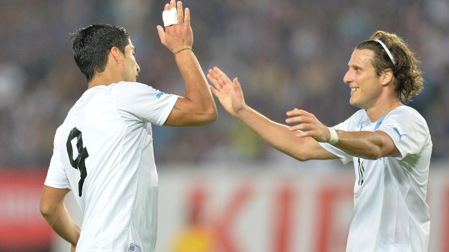 Luis Suarez comemora gol pela seleção uruguaia com Diego Forlan em jogo contra o Japão -  AFP PHOTO / KAZUHIRO NOGI