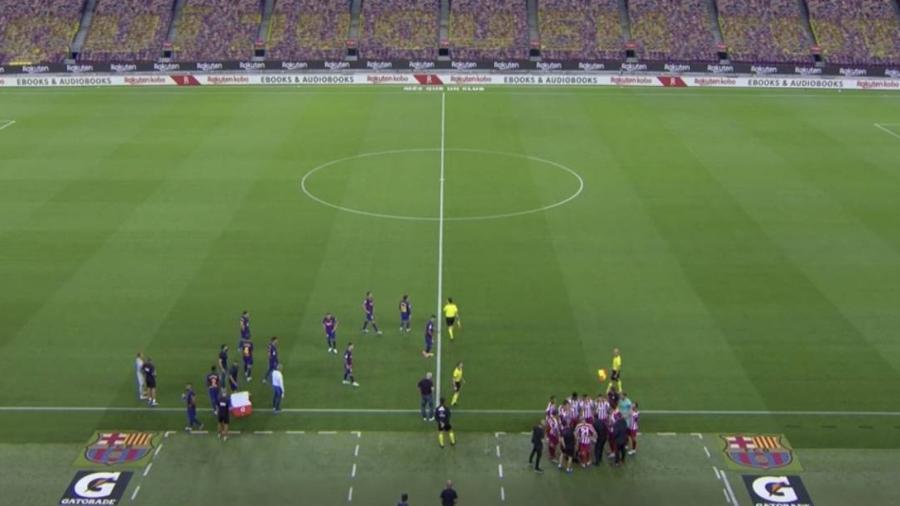 Durante parada técnica, jogadores do Barcelona se dispersaram enquanto se hidratavam; já os do Atlético formaram uma roda em torno do técnico Simeone - Reprodução