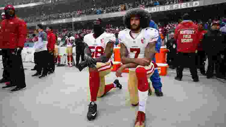 Colin Kaepernick (dir) e Eli Harold ajoelham na hora da execução do hino dos EUA no jogo entre San Francisco 49ers e Chicago Bears na NFL em 2018 - Michael Zagaris/San Francisco 49ers/Getty Images - Michael Zagaris/San Francisco 49ers/Getty Images