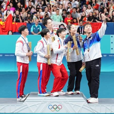 Atleta faz selfie em pódio das duplas mistas do tênis de mesa nas Olimpíadas de Paris