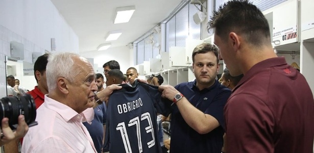 Observado por Leco (à esquerda) e Denis (à direita), Pinotti mostra camisa feita em homenagem ao goleiro - Rubens Chiri / saopaulofc.net