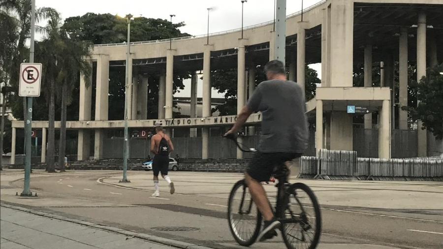 Ciclista e corredor praticam suas atividades físicas próximos à estátua do Bellini, no Maracanã - Bruno Braz / UOL Esporte