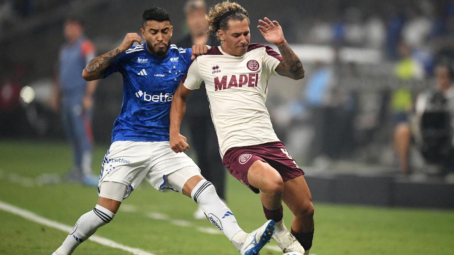 William e Boggio disputam lance durante jogo entre Cruzeiro e Lanús pela Sul-Americana