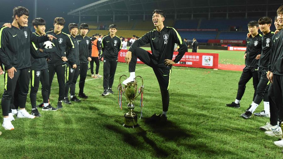 Jogador da seleção sul-coreana sub-18 pisa em troféu durante comemoração da Copa Panda - STR/AFP
