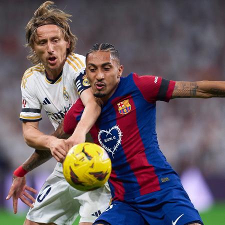 Modric e Raphinha disputam a bola durante Real Madrid x Barcelona, jogo do Campeonato Brasileiro