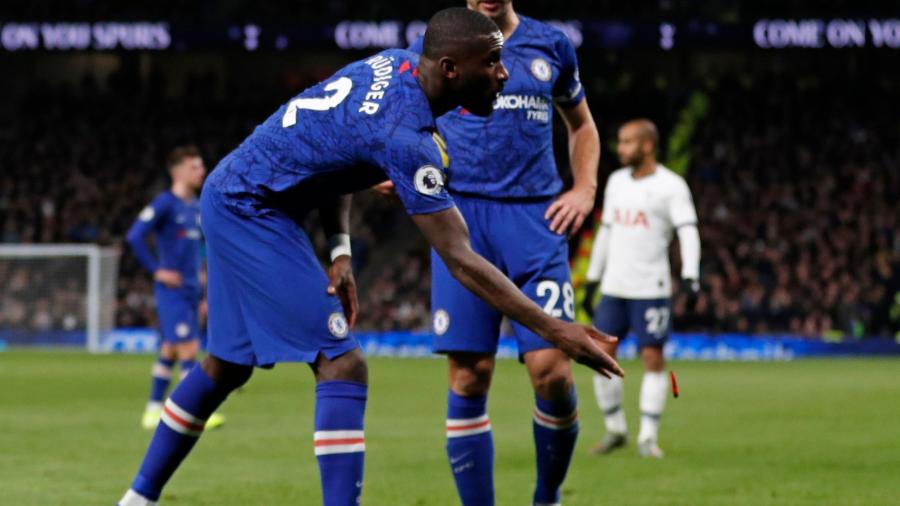 Antonio Rudiger, zagueiro do Chelsea, retira objeto atirado no gramado durante vitória fora de casa sobre o Tottenham por 2 a 0 pelo Campeonato Inglês - Adrian Dennis/AFP