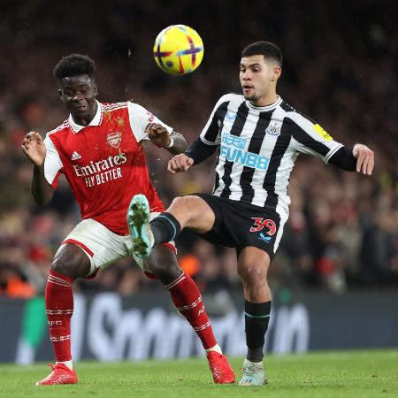 Bukayo Saka (Arsenal) e Bruno Guimarães (Newcastle) disputam bola em partida pelo Campeonato Inglês.