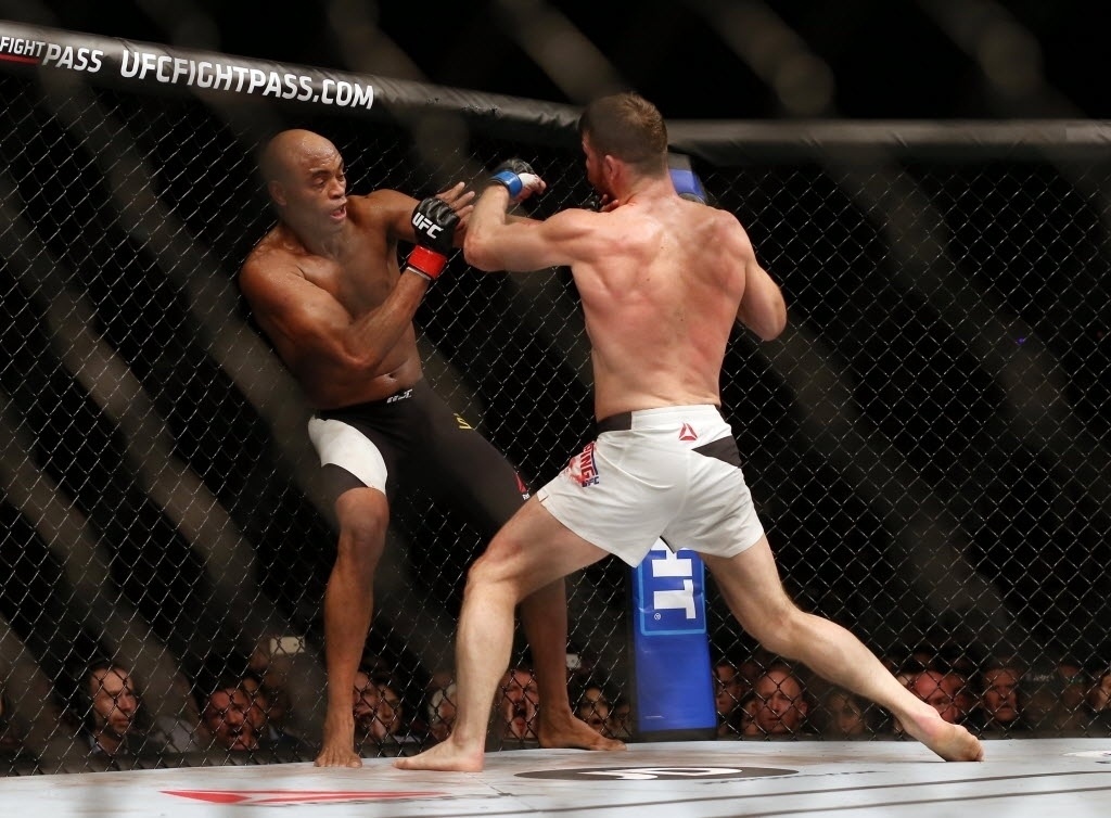 Anderson Silva (esq.) tenta se esquivar de golpe de Michael Bisping, na luta principal do UFC em Londres, neste sábado (27)