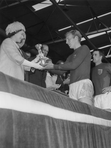 Na Copa do Mundo de 1966 a Rainha Elizabeth II entregou a taça Jules Rimet a Bobby Moore, capitão da seleção inglesa - Central Press/Getty Images