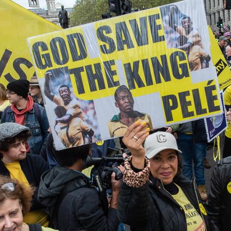 Brasileiros levantam cartaz com homenagem ao Rei Pelé em protesto antes da coroação de Charles 3º - Guy Smallman/Getty Images