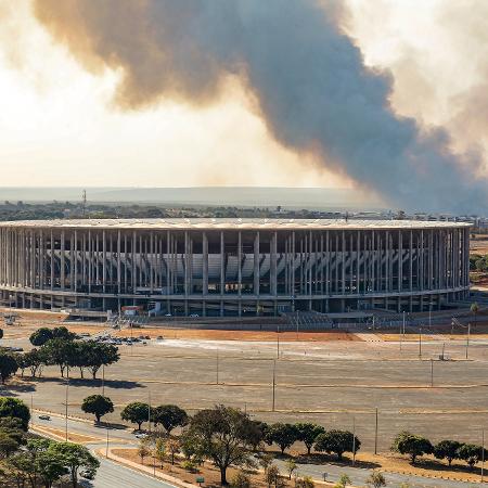 Estádio Mané Garrincha, em Brasília, com fumaça ao fundo