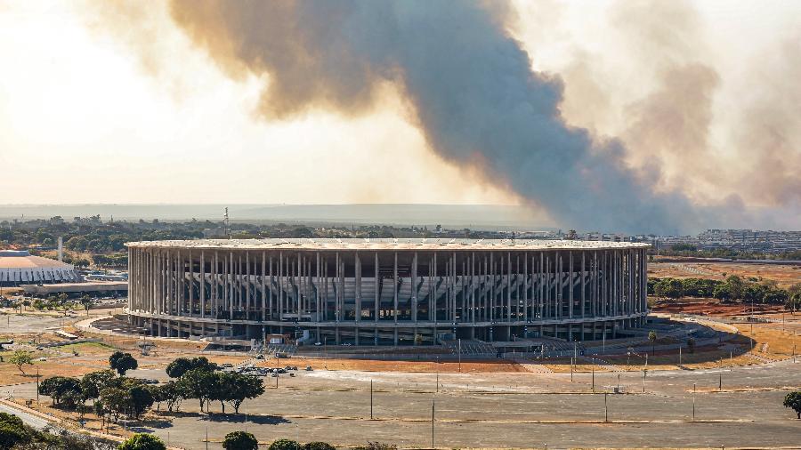 Estádio Mané Garrincha, em Brasília, com fumaça ao fundo