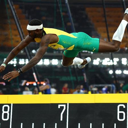 Carey McLeod, atleta de salto em distância da Jamaica, perde equilíbrio após salto durante o Mundial de Atletismo