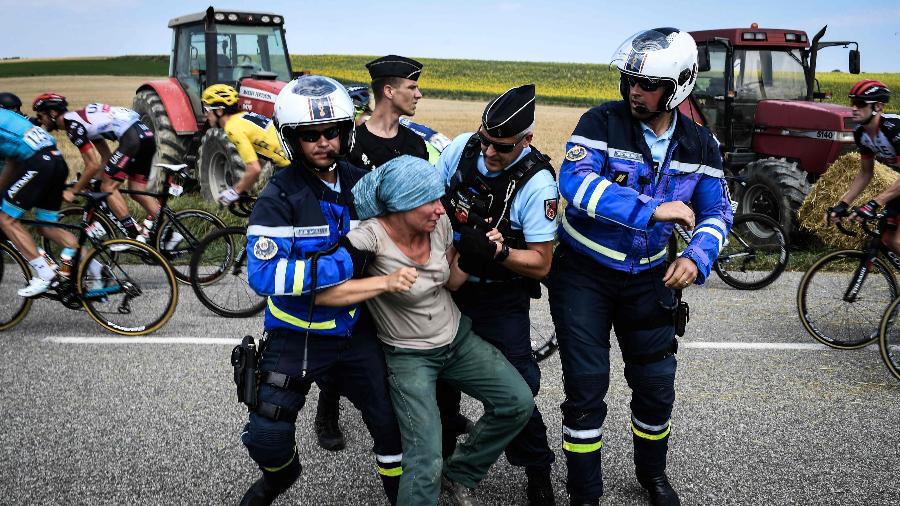 Agricultores são retirados pela polícia de pista durante Volta da França - AFP PHOTO / Jeff PACHOUD