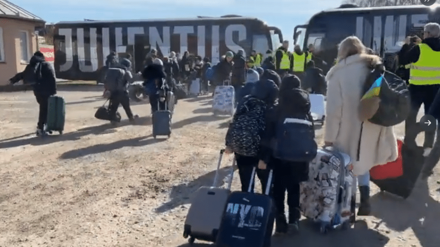 Momento em que refugiados embarcam em ônibus do clube - Reprodução/Twitter