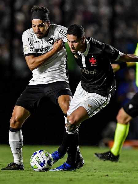 Eduardo, do Botafogo, e Praxedes, do Vasco, disputam a bola em partida do Campeonato Brasileiro