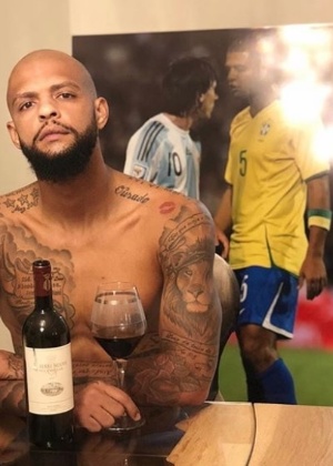 Felipe Melo tomando vinho com painel encarando Messi de fundo - Reprodução