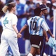Diego Maradona em campo acompanhando de representante do controle antidoping - Michael Kunkel/Bongarts/Getty Images