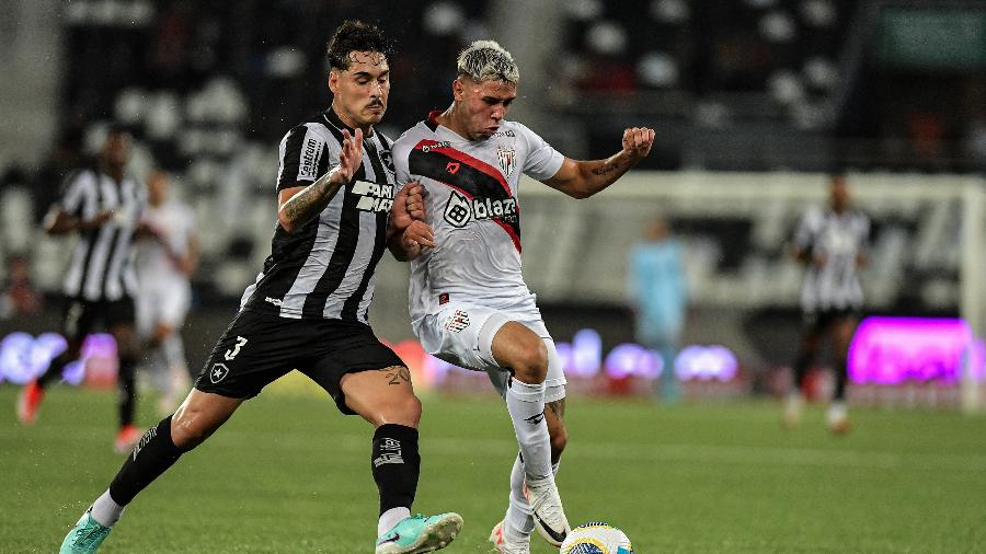 Lucas Halter e Emilio Rodríguez disputam a bola em Botafogo x Atlético Goianiense 