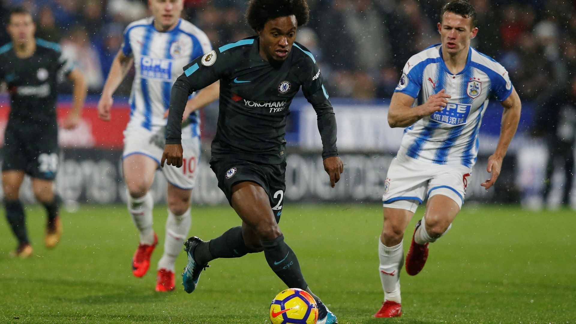 O brasileiro Willian em ação na partida entre Chelsea e Huddersfield, pelo Inglês