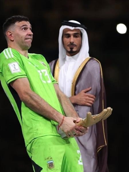 O goleiro Dibu Martinez faz gesto obsceno com o troféu de luva de ouro da Copa do Mundo do Qatar - Divulgação/Fifa