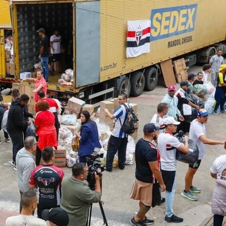 Torcedores do São Paulo mobilizados para carregar caminhões dos Correios com donativos para o RS - Rubens Chiri / São Paulo FC