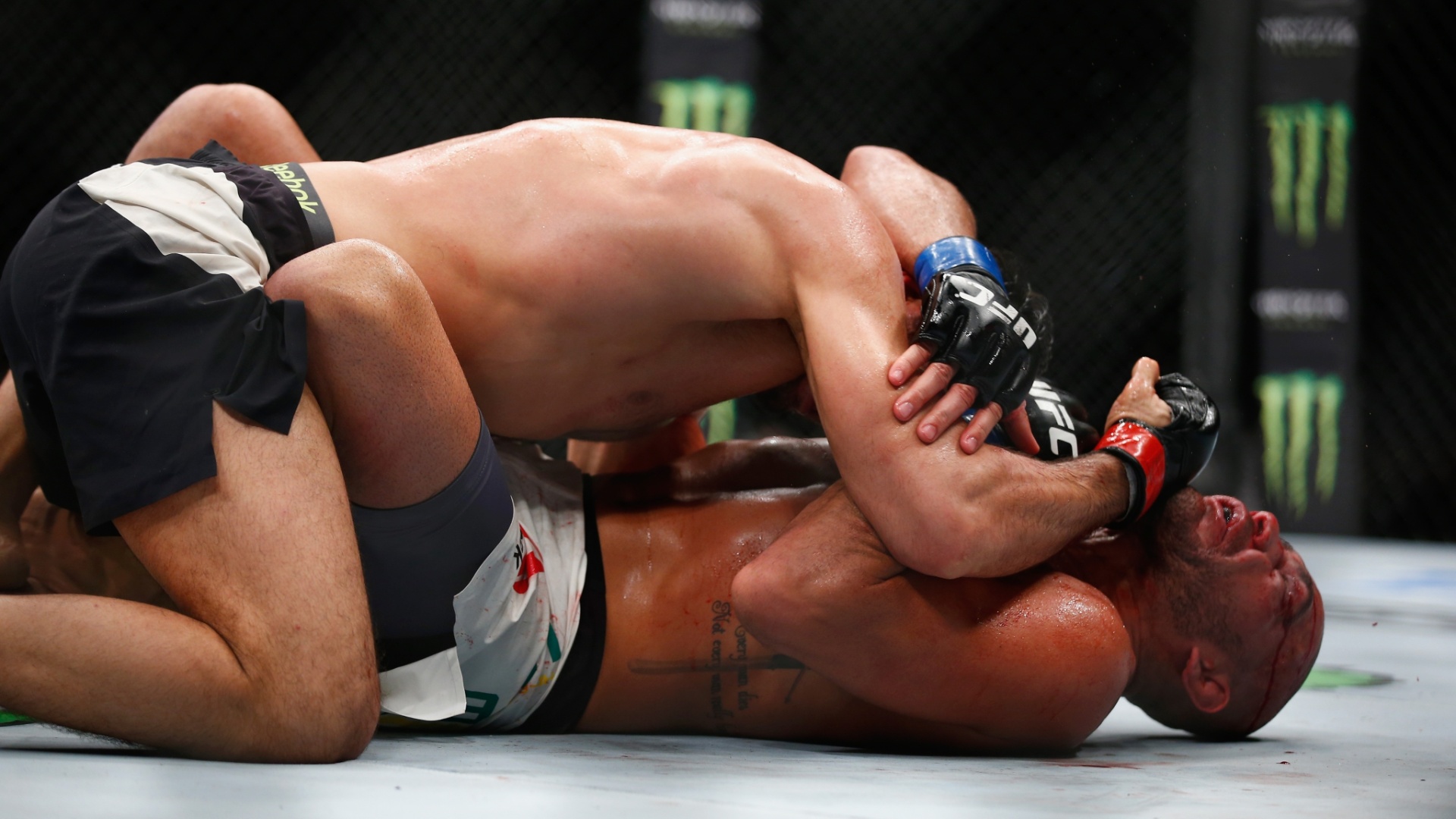 Gegard Mousasi (topo) castiga o brasileiro Thales Leites no ground and pound, em luta neste sábado (27), no UFC em Londres