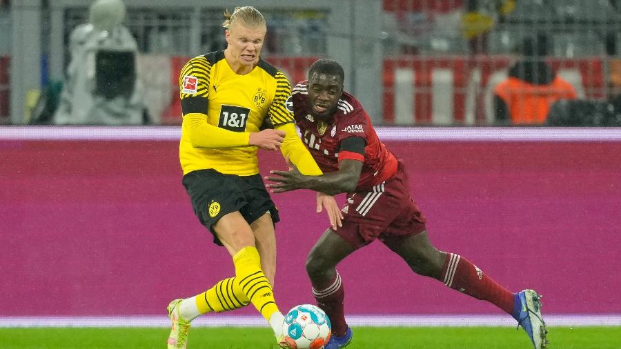 Haaland e Upamecano disputam bola durante clássico entre Dortmund e Bayern no Campeonato Alemão - Alex Gottschalk/DeFodi Images via Getty Images