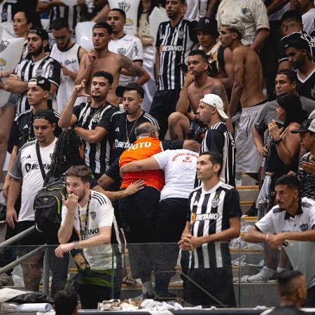 Fotógrafo atingido por bomba atirada por torcedores na final da Copa do Brasil sendo retirado pela arquibancada do estádio