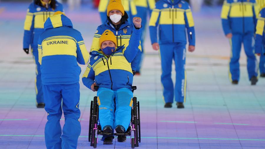 Atleta ucraniano ergue o braço com o punho cerrado na cerimônia de abertura das Paralimpíadas de Inverno de Pequim - Carmen Mandato/Getty Images