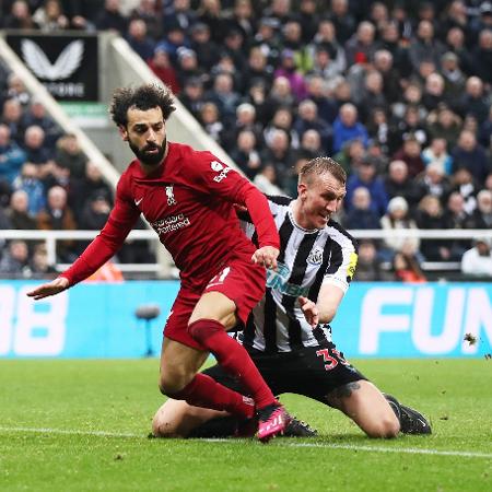 Salah, do Liverpool, disputa bola com Dan Burn, do Newcastle, durante jogo pelo Campeonato Inglês