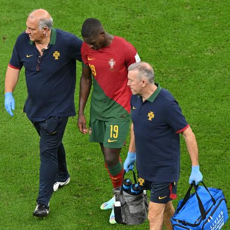 Nuno Mendes deixa o gramado com lesão e chorando durante jogo entre Portugal e Gana na Copa do Mundo do Qatar - Glyn KIRK / AFP