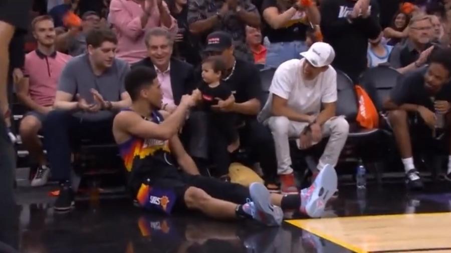 Devin Booker, jogador do Phonix Suns, comemorou uma cesta cumprimentando um bebê durante os Playoffs da NBA - Reprodução/Twitter