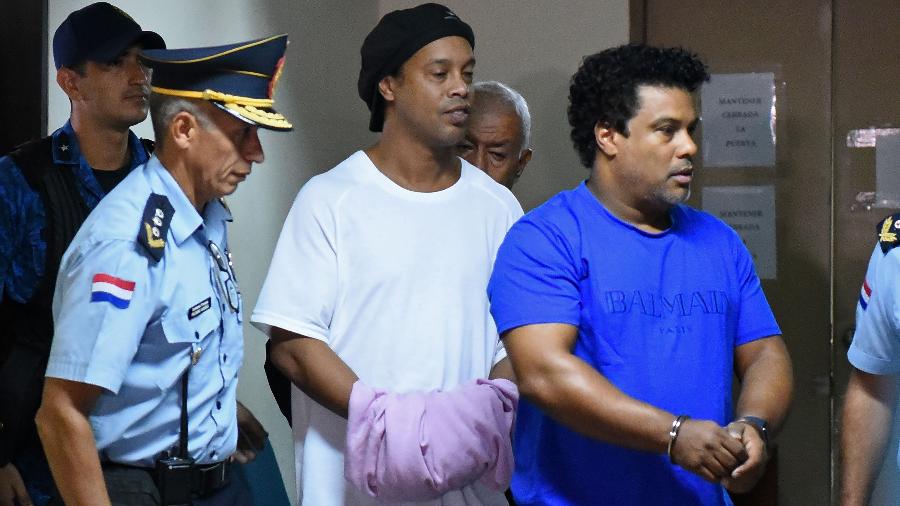 Ronaldinho e Assis chegam algemados para audiência de custódia no Paraguai - NORBERTO DUARTE/AFP