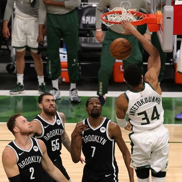 Giannis Antetokounmpo, do Milwaukee Bucks, enterra enquanto jogadores do Brooklyn Nets observam