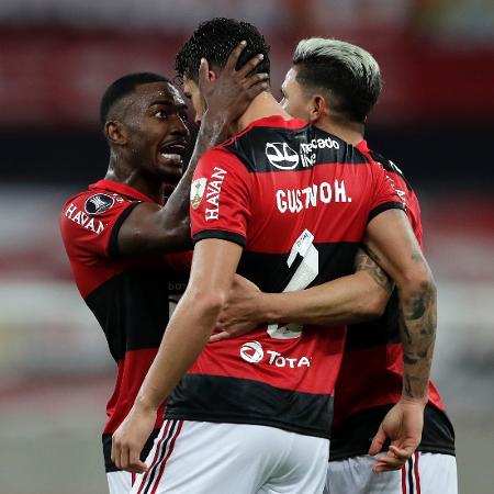 Gustavo Henrique é celebrado por Ramon (esq) e Arrascaeta, ao marcar gol da classificação do Flamengo sobre a LDU - Silvia Izquierdo-Pool/Getty Images