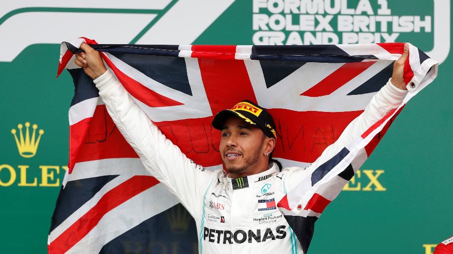 Hamilton abraça a bandeira britânica após vencer a corrida em casa pela sexta vez - Matthew Childs/Reuters