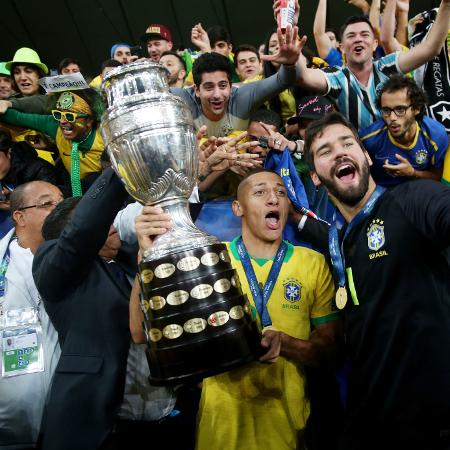 Alisson e Richarlison comemoram com a taça da Copa América de 2019