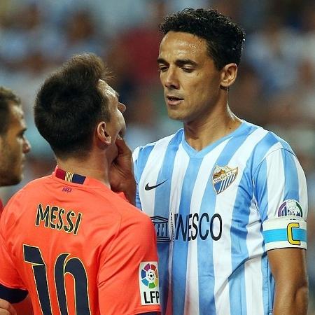 Zagueiro Weligton Robson segura Messi pelo pescoço durante Malaga x Barcelona em 2014 - Miguel Ruiz/FC Barcelona via Getty Images