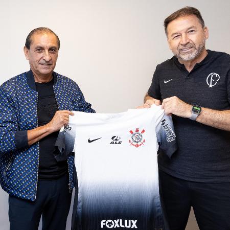O técnico Ramón Díaz posa segurando a camisa do Corinthians junto de Augusto Melo, presidente do Clube