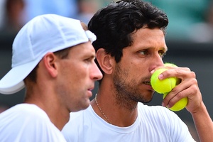 Marcelo Melo conversa com o polonês Lukasz Kubot durante a final de duplas de Wimbledon - AFP PHOTO / Glyn KIRK - AFP PHOTO / Glyn KIRK