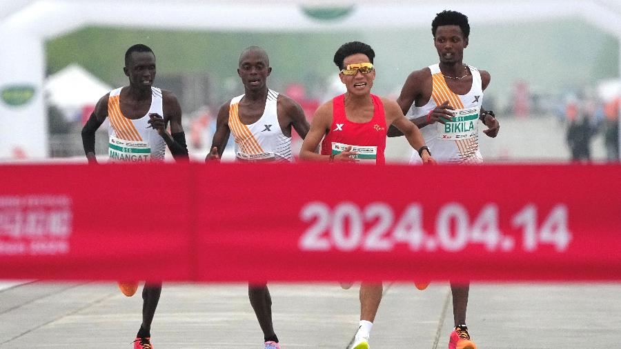 14.abr.2024 - Corredor chinês He Jie ligeiramente na frente do etíope Dejene Hailu Bikila e dos quenianos Robert Keter e Willy Mnangat, durante meia-maratona de Pequim - China Stringer Network via Reuters